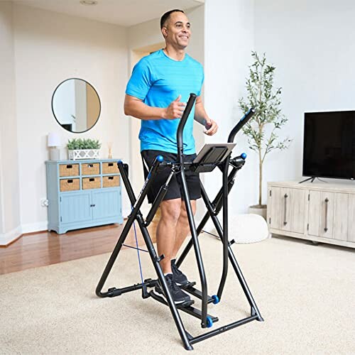 Man exercising on an elliptical machine in a living room.