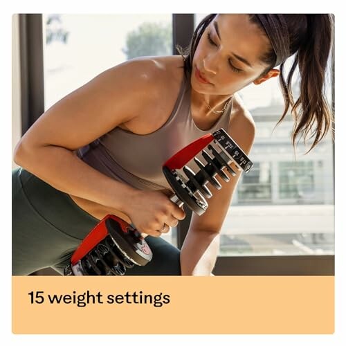 Woman exercising with adjustable dumbbell indoors.